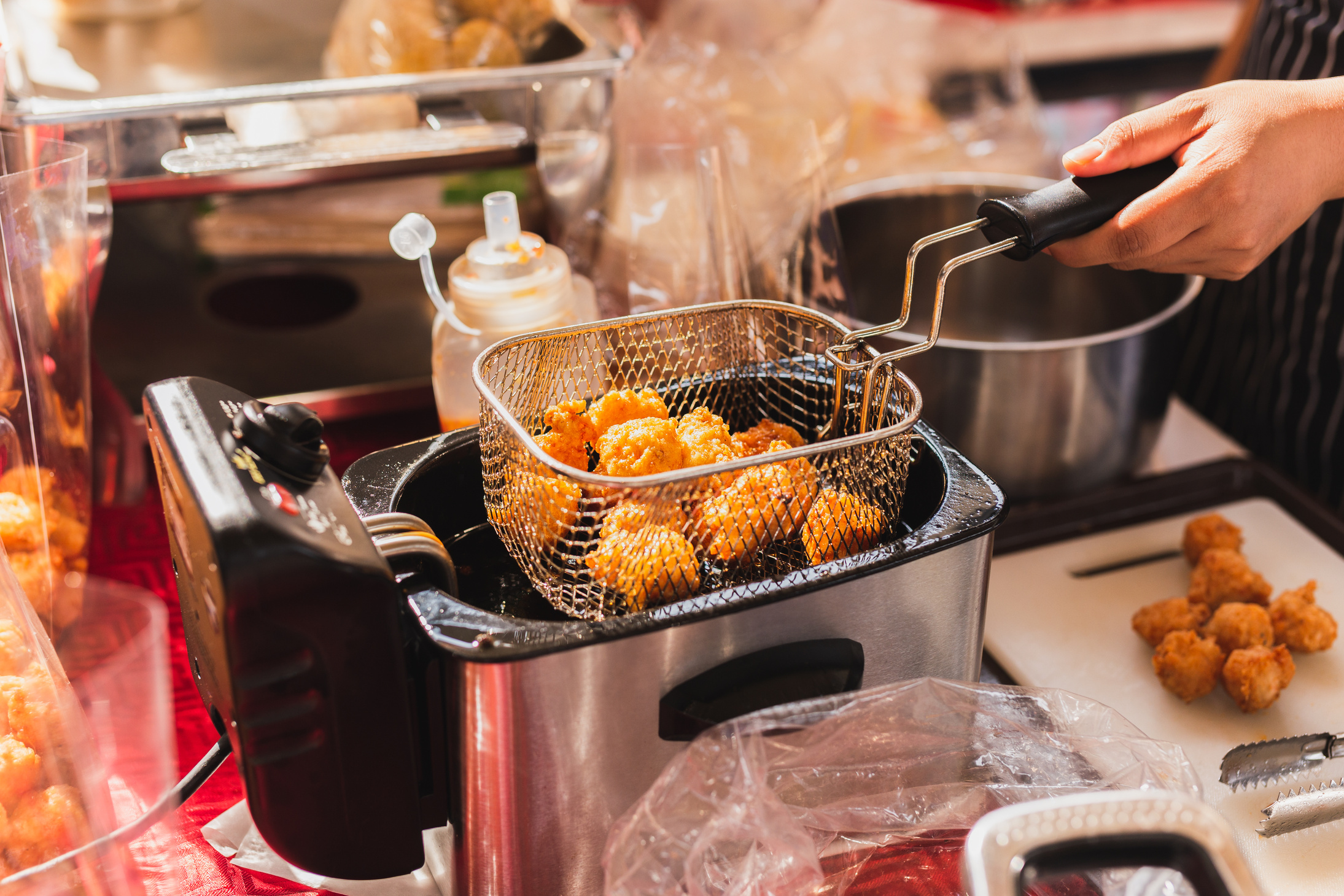 Female chef deep fried meat ball in kitchen.